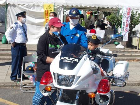 来場した子供がちびっ子警察官に扮装して白バイに乗っている状況