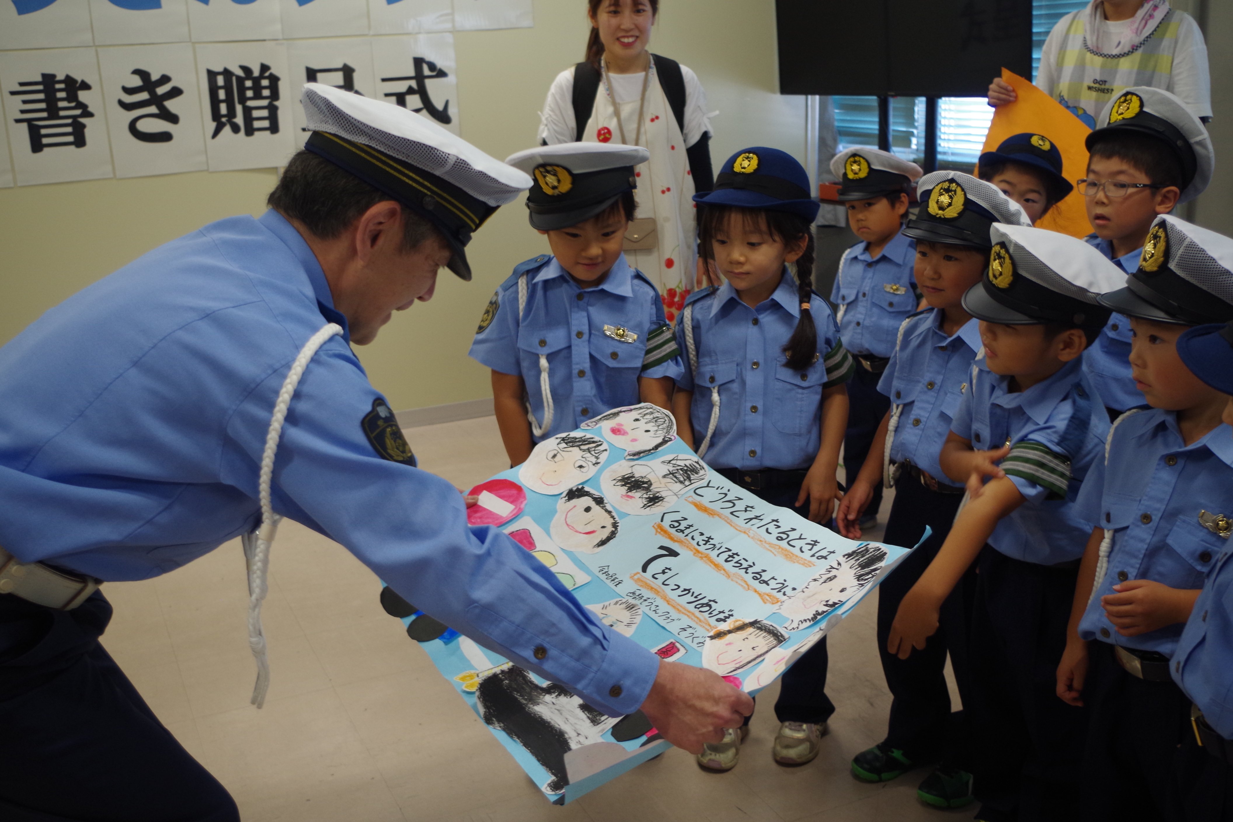 警察署長が寄せ書きを受け取る様子