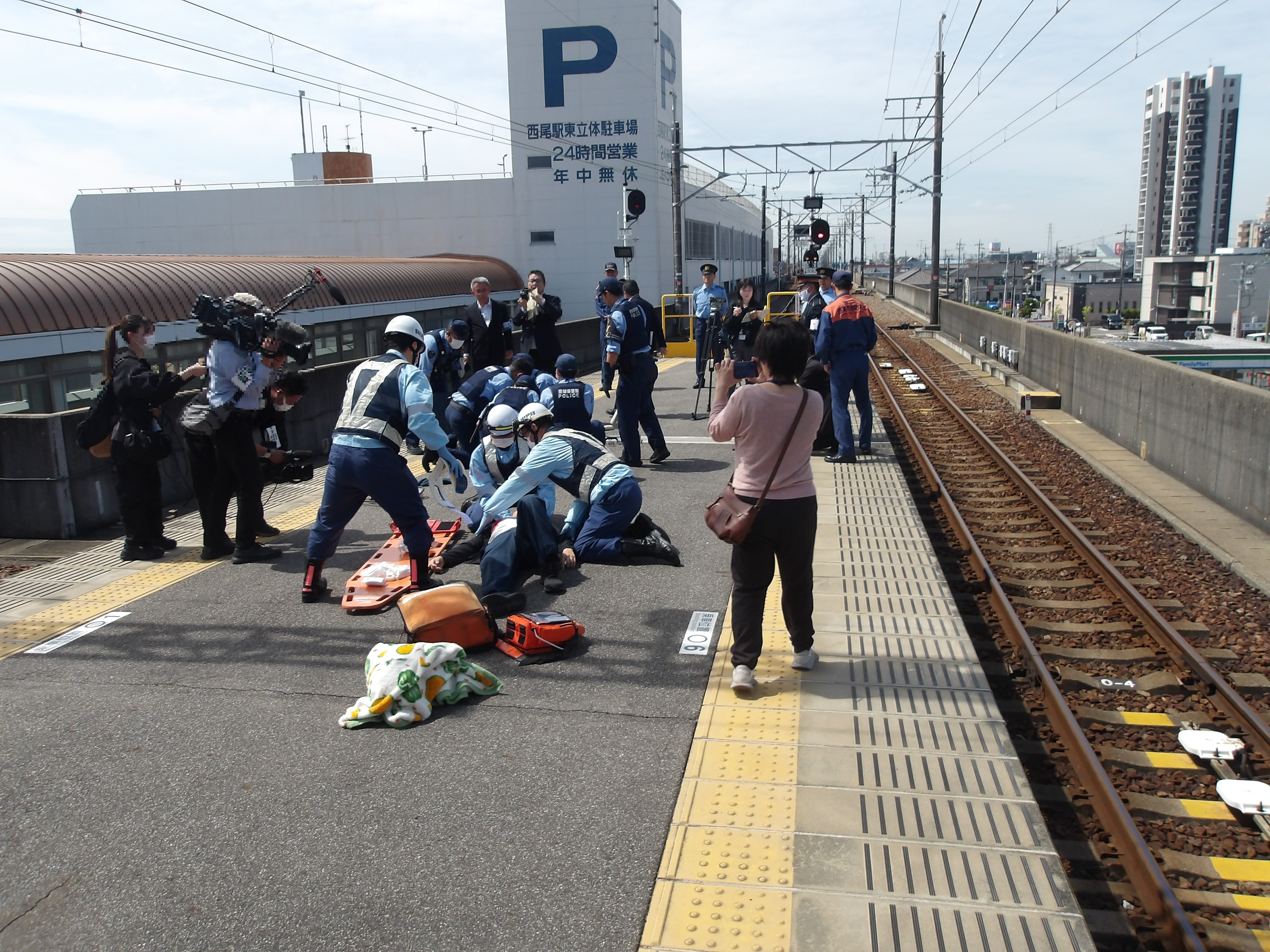 警察官が犯人を制圧逮捕し、消防と連携して負傷者の救護に当たっている状況