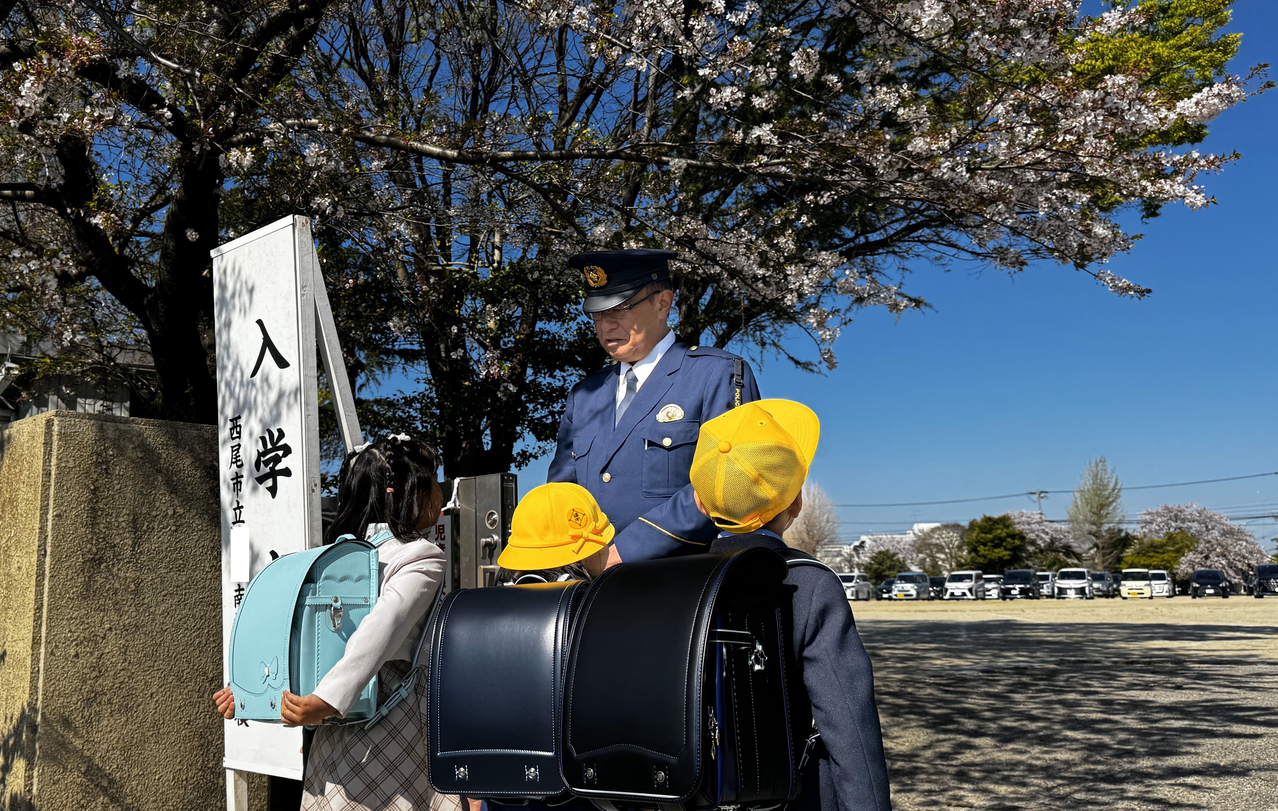 校門前で新入学児童とともに