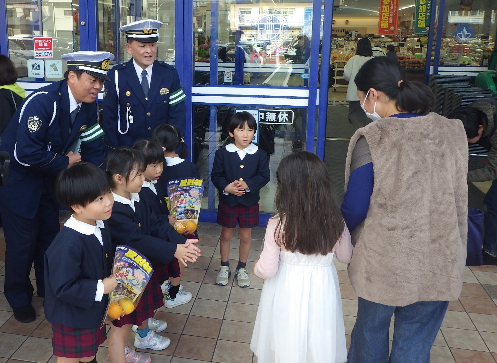 園児らが元気よく呼びかけながら啓発品を渡している