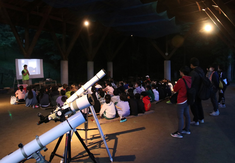 夜の野外で行われた星空観察会の様子