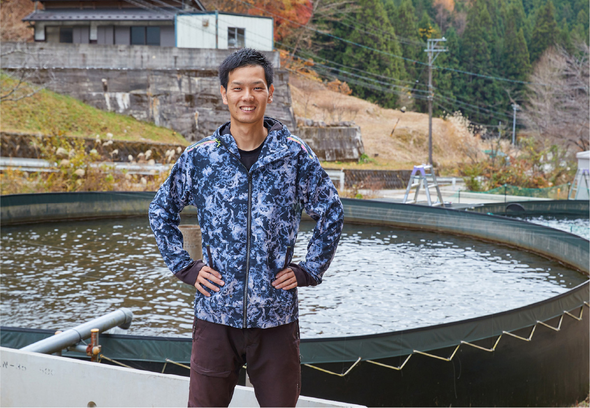 水槽をバックに立つ小早川さん