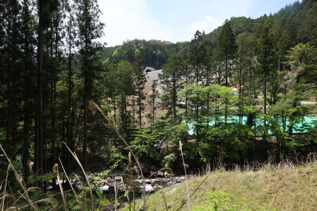 手前に豊川、奥の山に新しいトンネルが見える様子