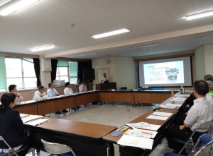 会議資料のスライドを見ている出席者