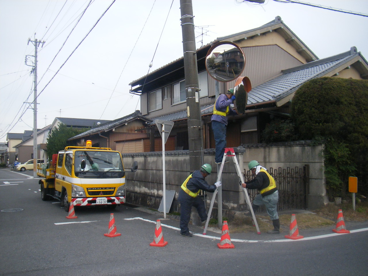 カーブミラーの方向を直しています。