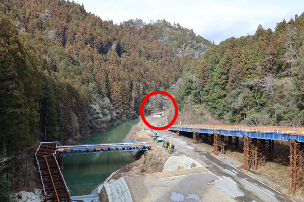 川沿いに旧三河田口駅である更地が位置する様子